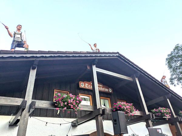 Goaßlschnalzer schnalzen vom Dach des Trachtenheims