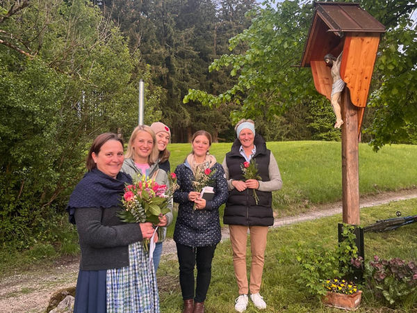 Frauen mit Blumen am Wegkreuz