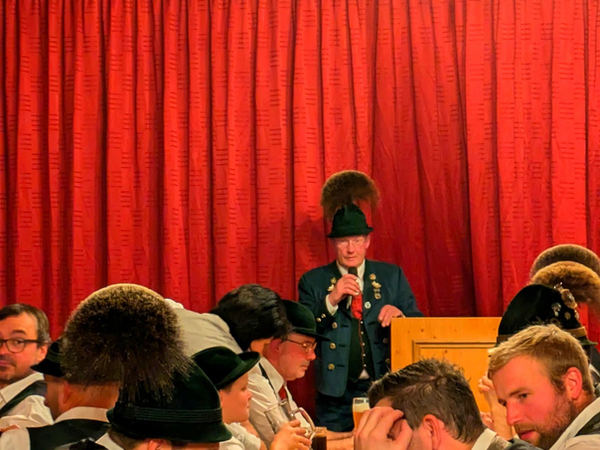 Musikant in Tracht vor rotem Vorhang